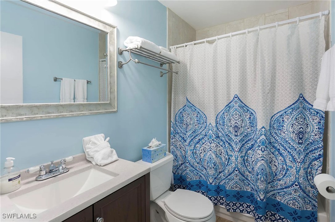 11093 Kelly Road Fort Myers, FL 33908 - Photo 10 of 12 a bathroom with a toilet sink and mirror
