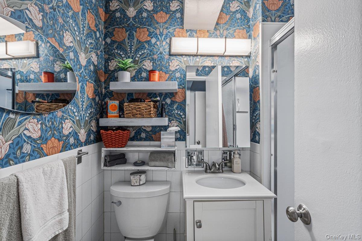 18-55 Corporal Kennedy Street, Unit 6H Queens, NY 11360 - Photo 15 of 18 Bathroom with wallpapered walls, wainscoting, and vanity