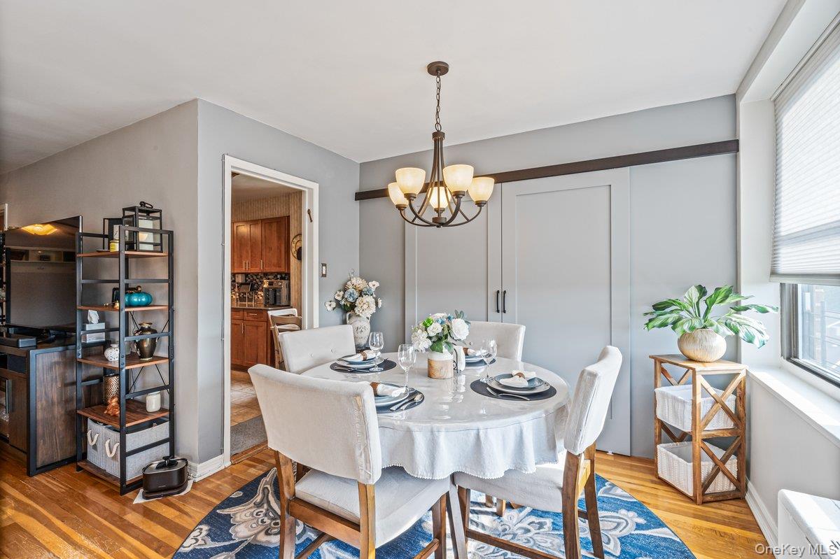 18-55 Corporal Kennedy Street, Unit 6H Queens, NY 11360 - Photo 6 of 18 Dining area featuring a chandelier and light wood-style floors
