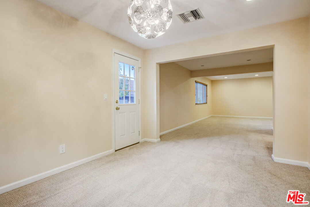 23620 Sunset Crossing Road Diamond Bar, CA 91765 - Photo 15 of 41 an empty room with a chandelier fan and windows