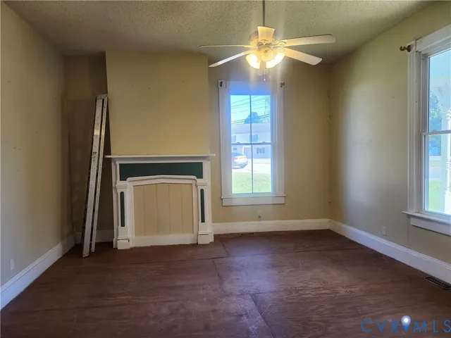 an empty room with windows and fan
