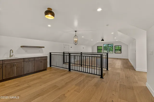 a view of hallway with wooden floor and chandelier