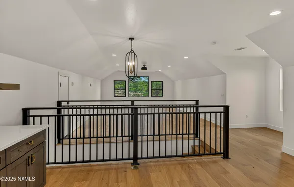 a kitchen with stainless steel appliances granite countertop a refrigerator a sink dishwasher and wooden cabinets with wooden floor