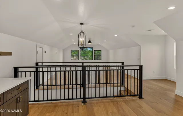 a kitchen with stainless steel appliances granite countertop a refrigerator a sink dishwasher and wooden cabinets with wooden floor