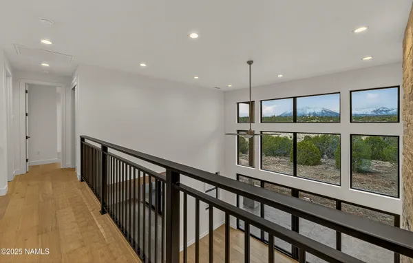 a view of a hallway with wooden floor and windows