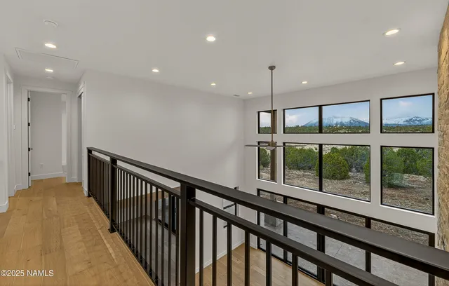 a view of a hallway with wooden floor and windows