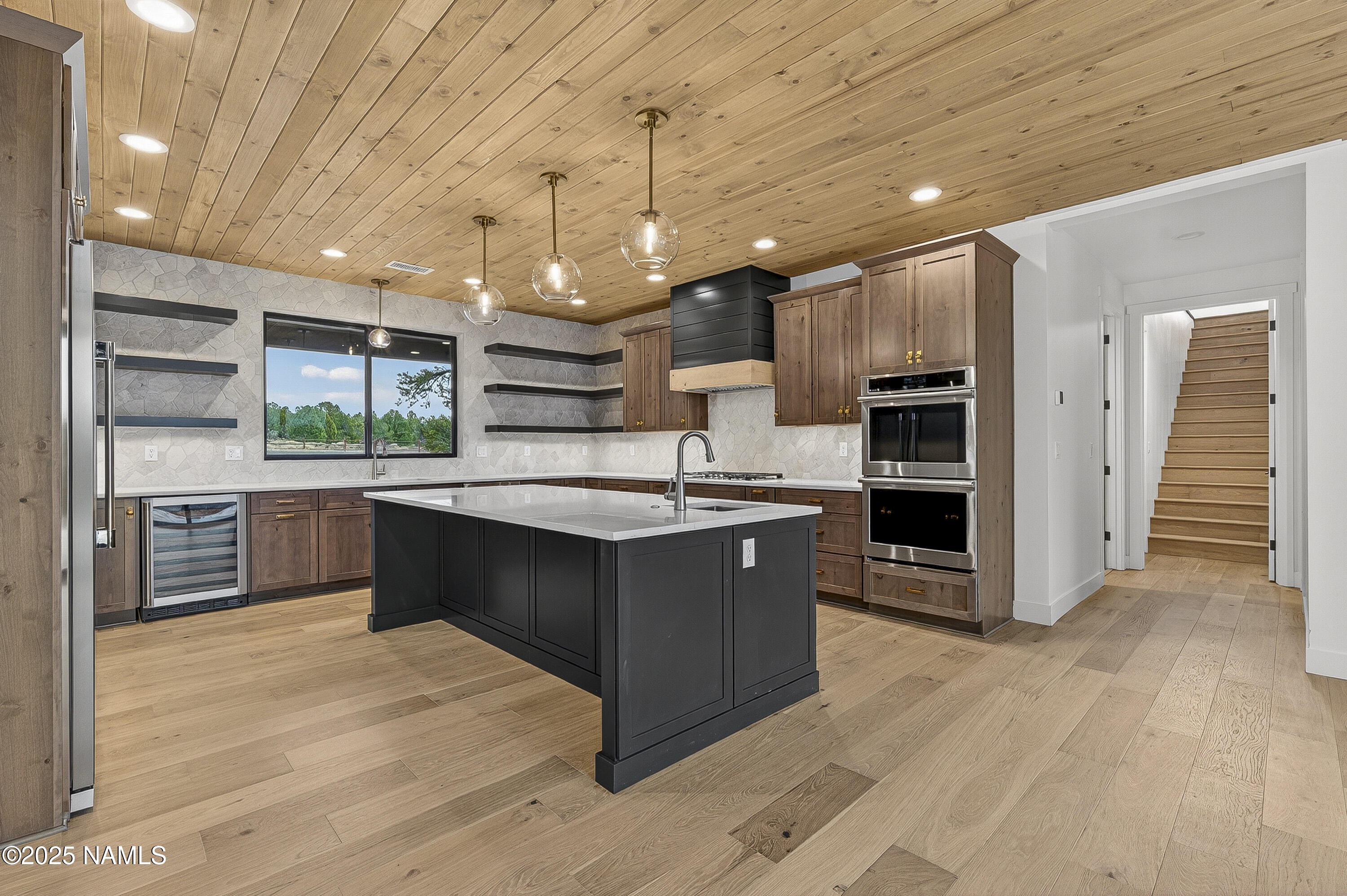 8488 Tall Tales Rnch Road Flagstaff, AZ 86004 - Photo 5 of 52 a large kitchen with stainless steel appliances kitchen island granite countertop a large counter top and wooden floors