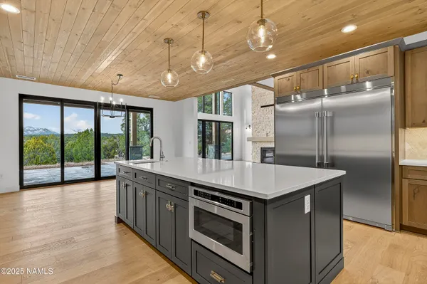 a large kitchen with stainless steel appliances granite countertop a large counter top a stove and a refrigerator