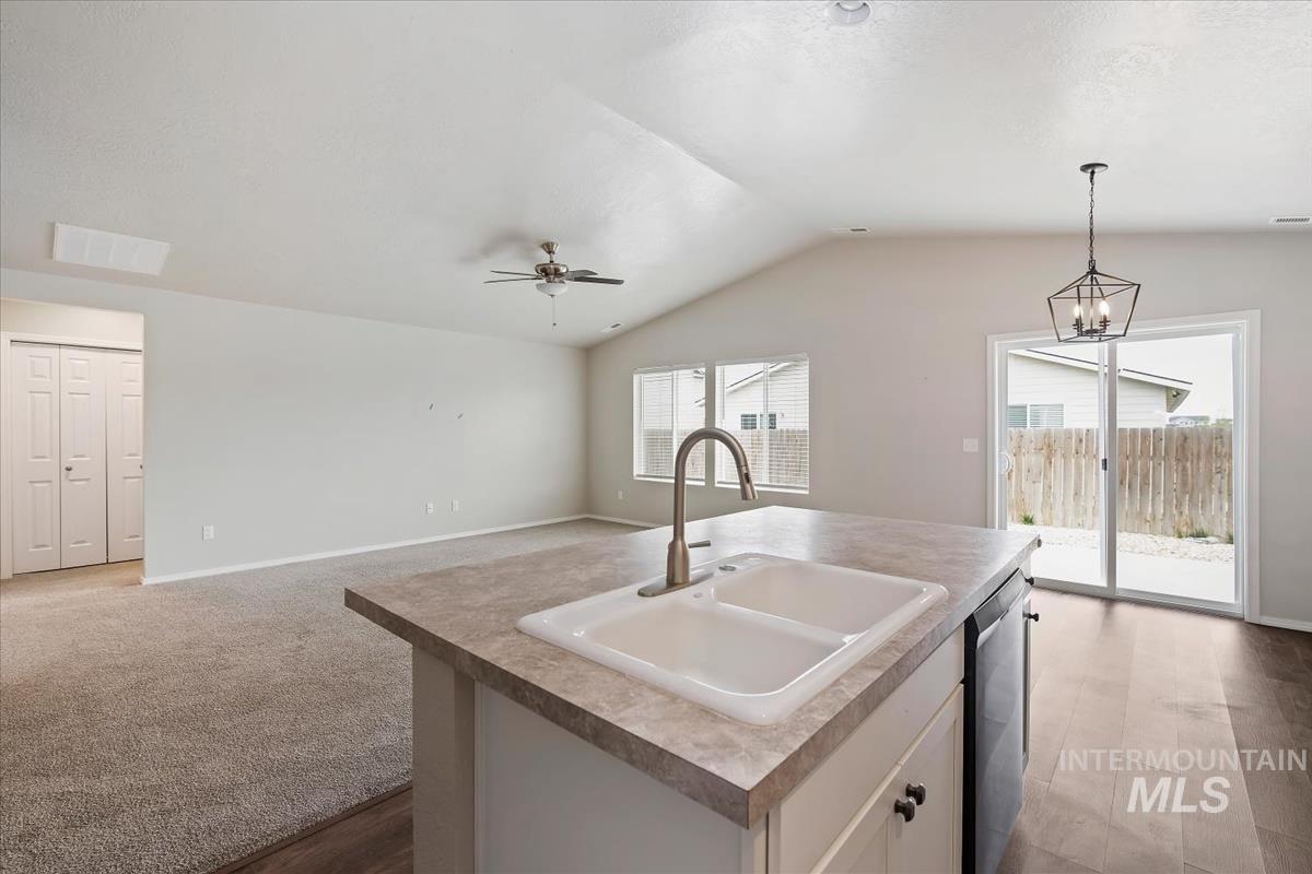1685 Southwest Levant Way Mountain Home, ID 83647 - Photo 31 of 31 Kitchen featuring open floor plan, lofted ceiling, a kitchen island with sink, stainless steel dishwasher, and a ceiling fan