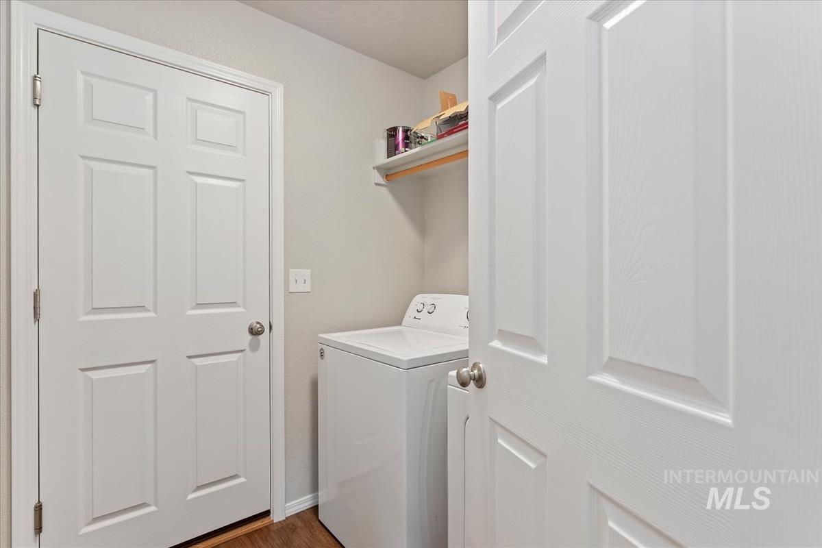 1685 Southwest Levant Way Mountain Home, ID 83647 - Photo 16 of 31 Laundry room with washer / clothes dryer and dark wood-style flooring