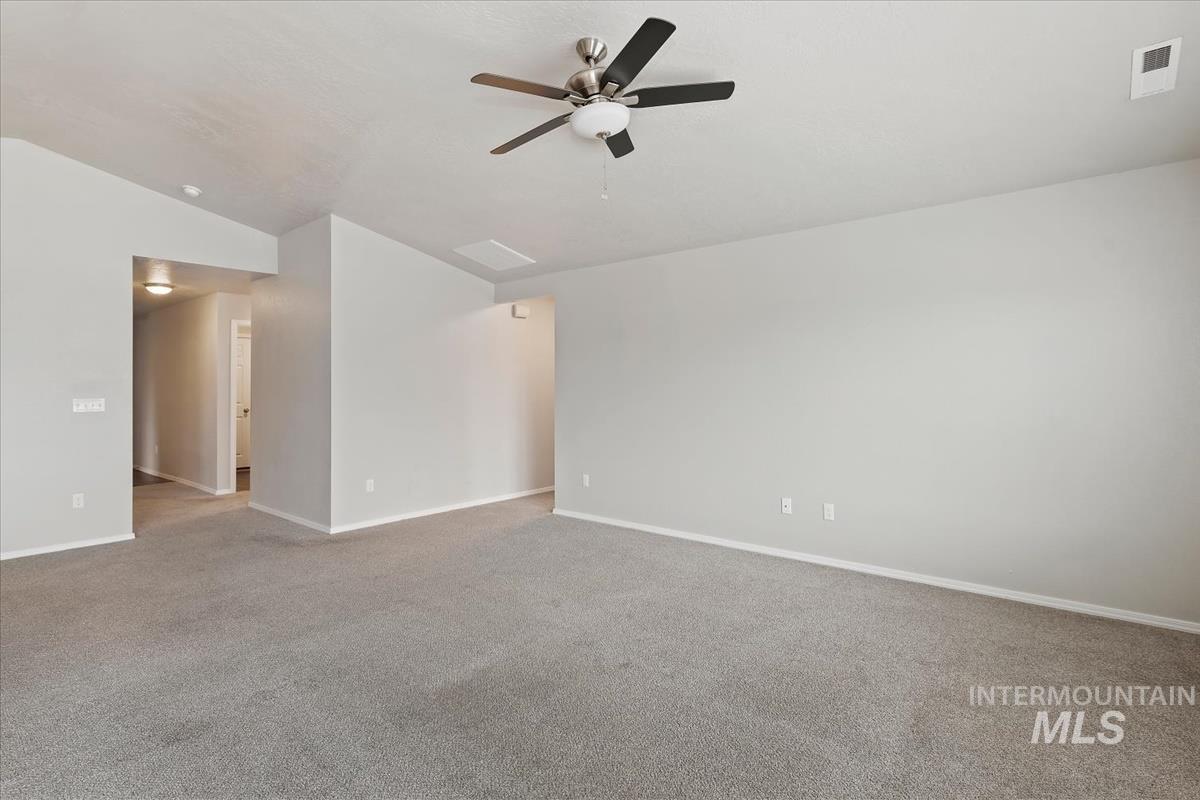 1685 Southwest Levant Way Mountain Home, ID 83647 - Photo 19 of 31 Carpeted empty room with vaulted ceiling and ceiling fan
