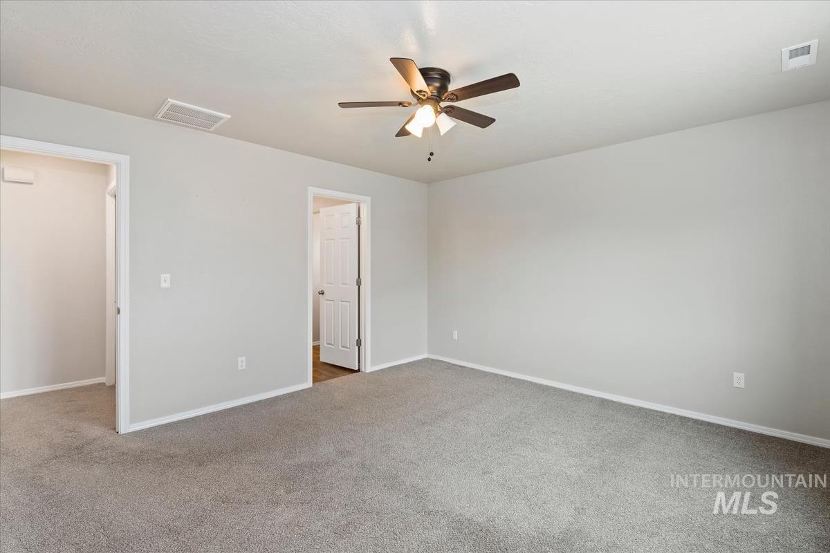 1685 Southwest Levant Way Mountain Home, ID 83647 - Photo 21 of 31 Unfurnished bedroom with light carpet and ceiling fan