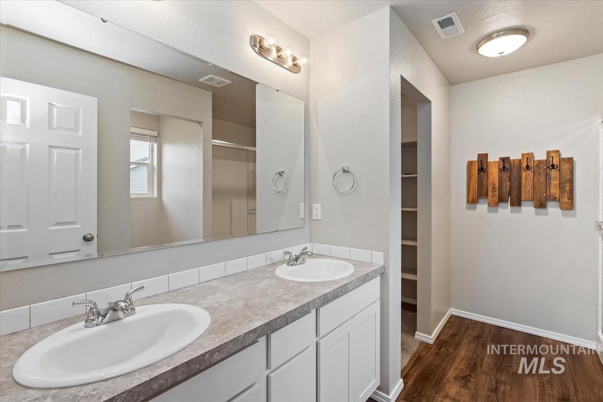 1685 Southwest Levant Way Mountain Home, ID 83647 - Photo 23 of 31 Full bath featuring double vanity, dark wood finished floors, and a spacious closet