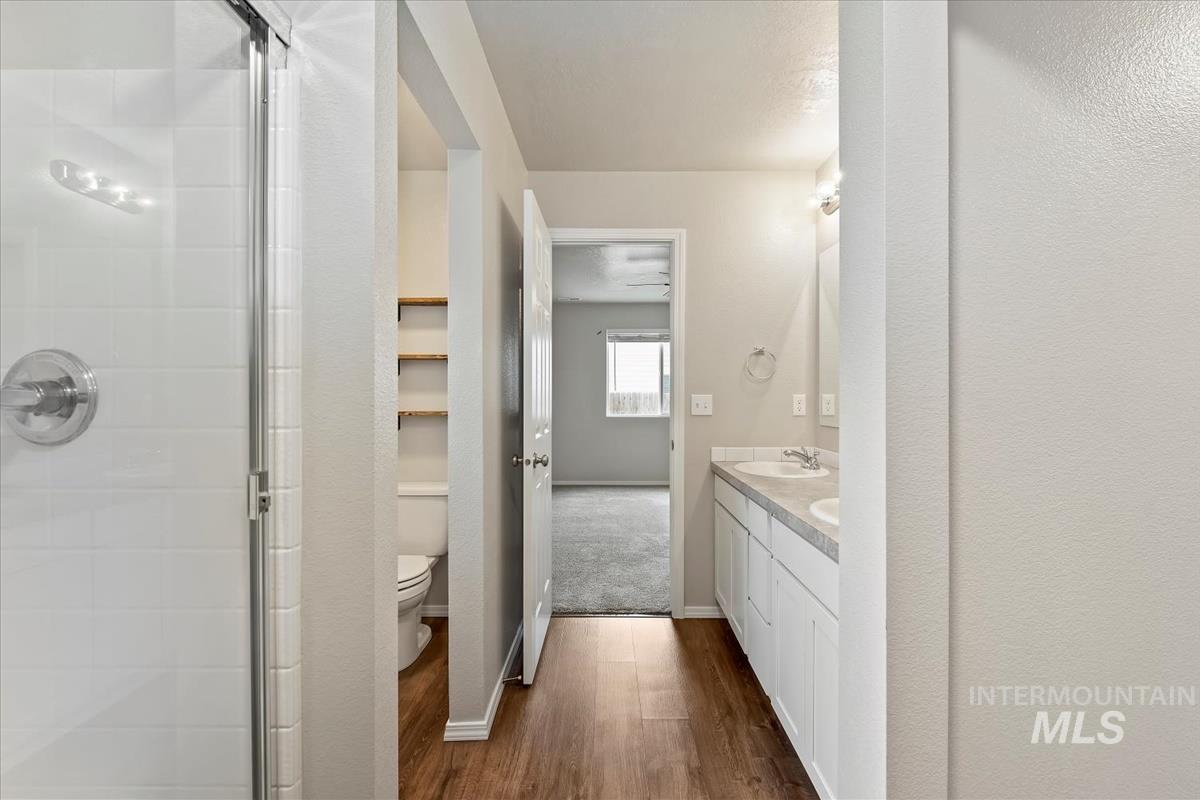 1685 Southwest Levant Way Mountain Home, ID 83647 - Photo 24 of 31 Bathroom featuring double vanity, a stall shower, and dark wood-type flooring