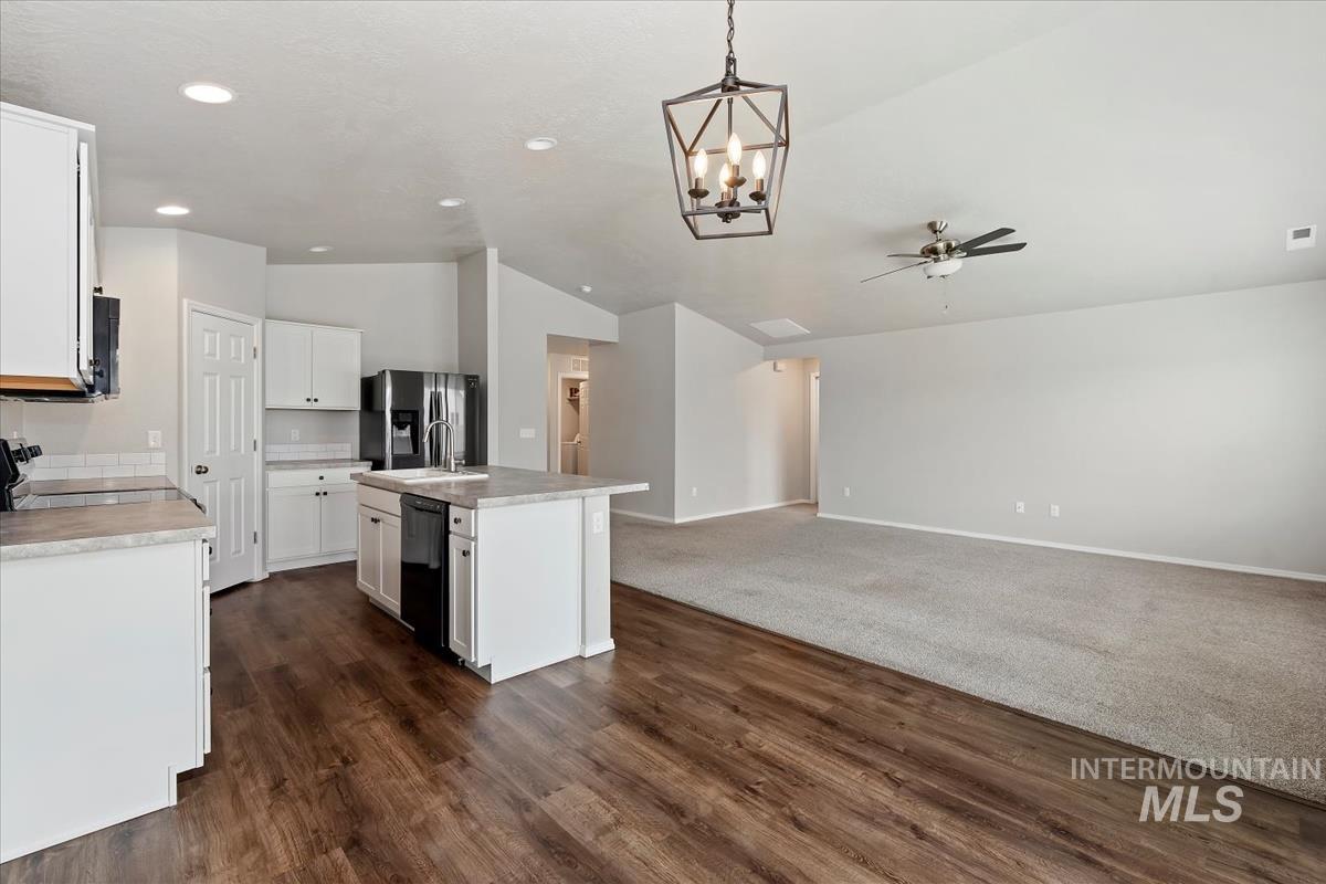 1685 Southwest Levant Way Mountain Home, ID 83647 - Photo 5 of 31 Kitchen featuring lofted ceiling, white cabinetry, light countertops, suspended lighting, and ceiling fan