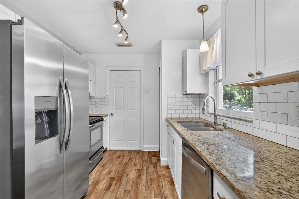 36 Bay Ridge Loop Mascotte, FL 34753 - Photo 13 of 32 a kitchen with stainless steel appliances granite countertop a sink stove and refrigerator