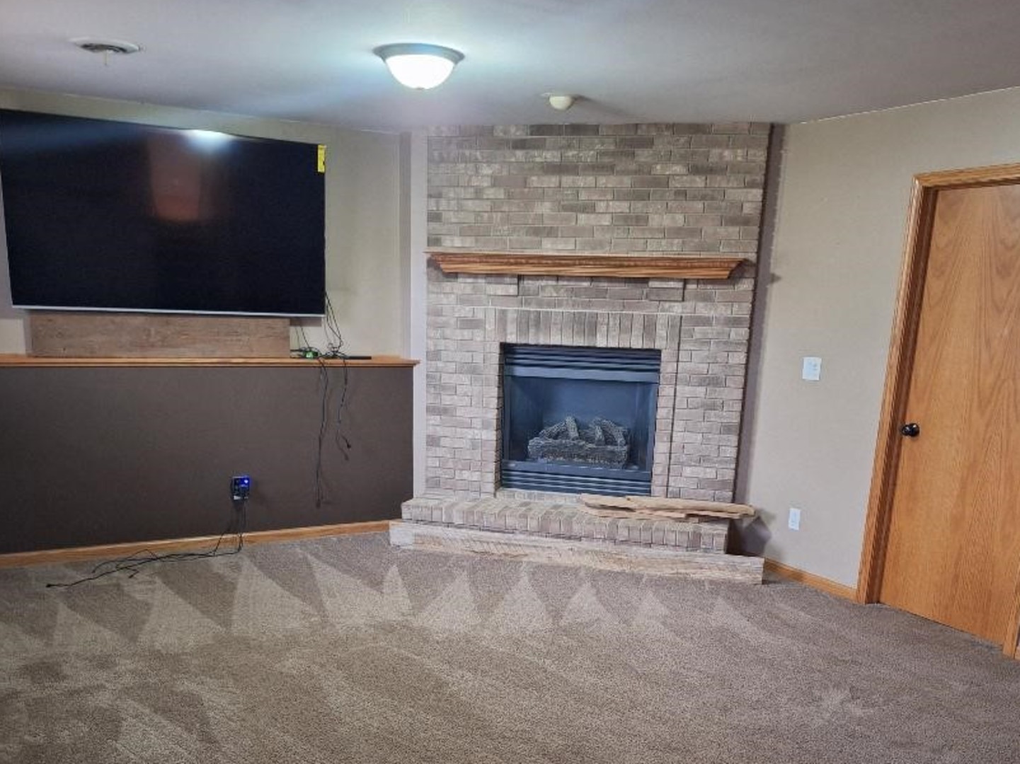 602 Sandra Street Kingston, IL 60145 - Photo 7 of 9 a living room with a fireplace and a flat screen tv