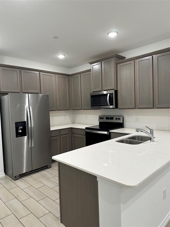 3004 Baneberry Lane, Unit 43 Mesquite, TX 75150 - Photo 2 of 16 a kitchen with granite countertop a refrigerator a sink a stove a microwave a counter space and cabinets