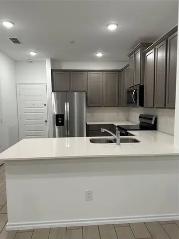 a large white kitchen with stainless steel appliances
