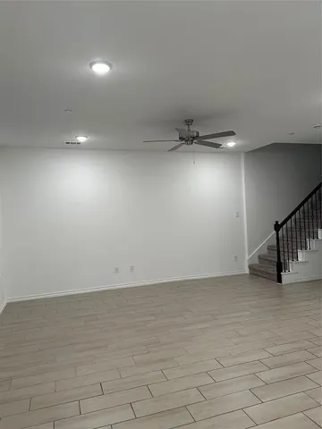 an empty room with stairs and windows