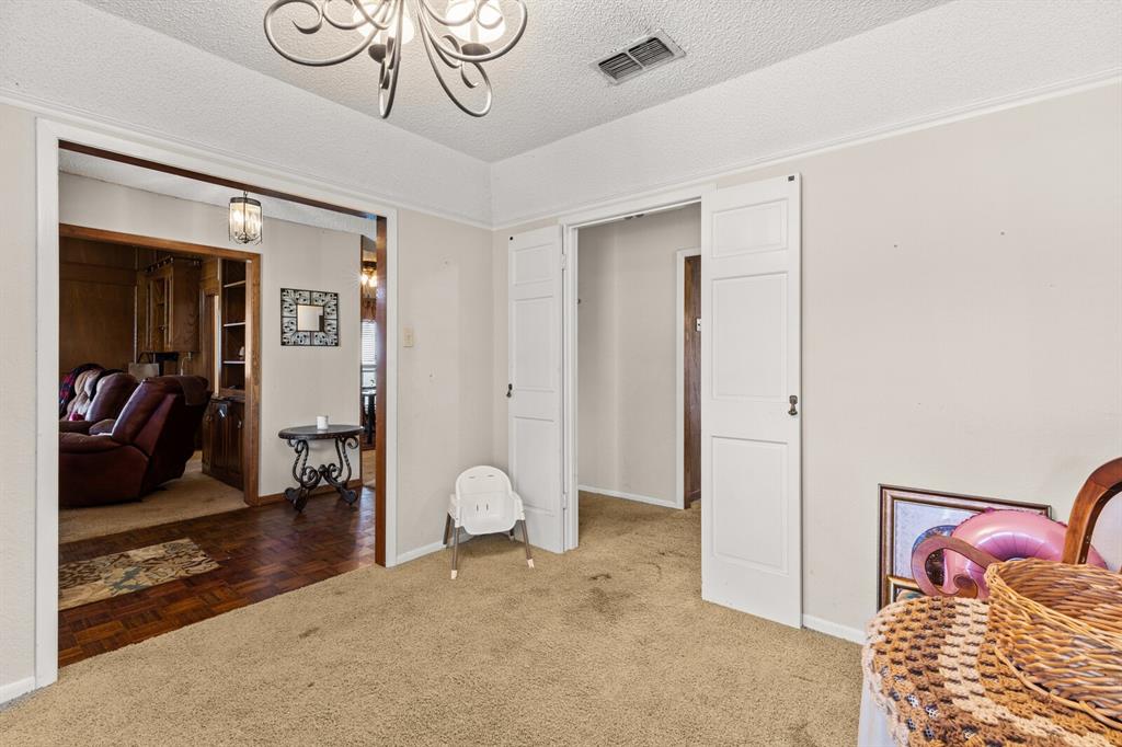 1502 Hinchliffe Road Mexia, TX 76667 - Photo 11 of 40 Living area with a textured ceiling, a chandelier, light carpet, baseboards, and visible vents