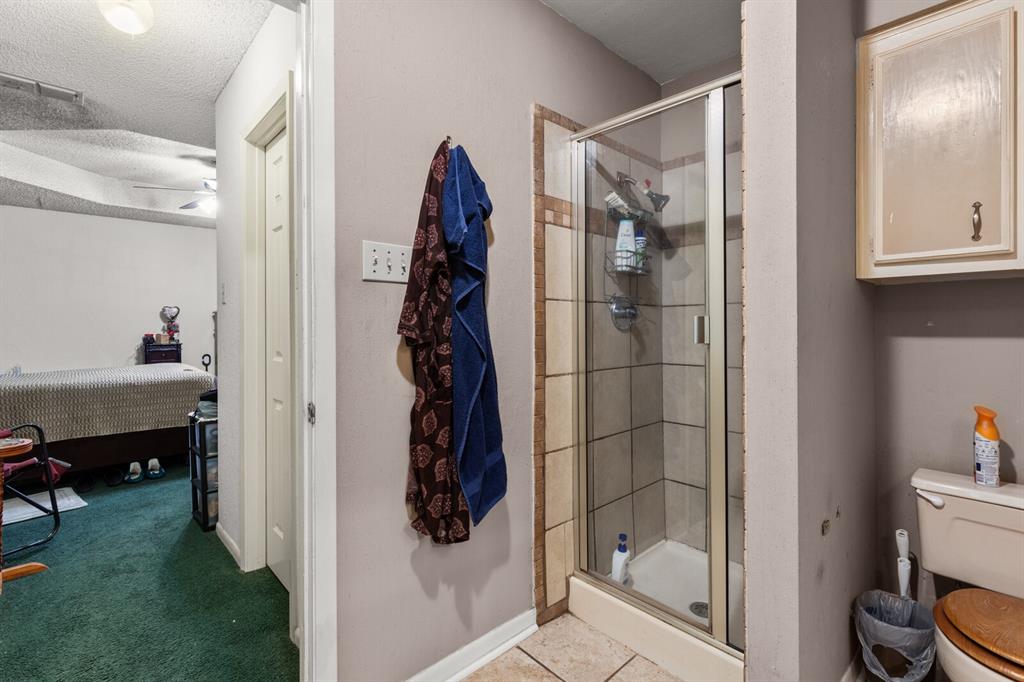 1502 Hinchliffe Road Mexia, TX 76667 - Photo 20 of 40 Ensuite bathroom with a textured ceiling, toilet, a stall shower, ensuite bathroom, and visible vents