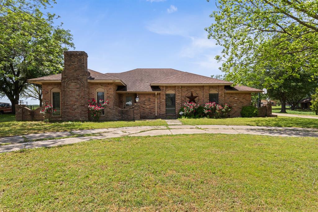 1502 Hinchliffe Road Mexia, TX 76667 - Photo 4 of 40 View of front facade with brick siding, roof with shingles, a chimney, and a front yard