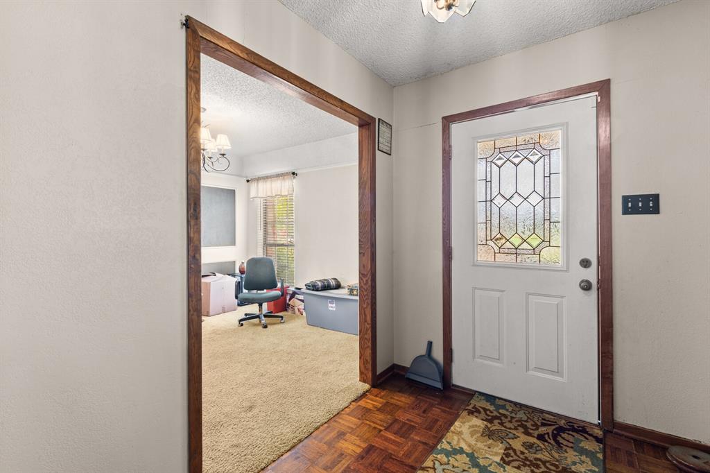 1502 Hinchliffe Road Mexia, TX 76667 - Photo 9 of 40 Foyer featuring dark colored carpet, baseboards, and a textured ceiling