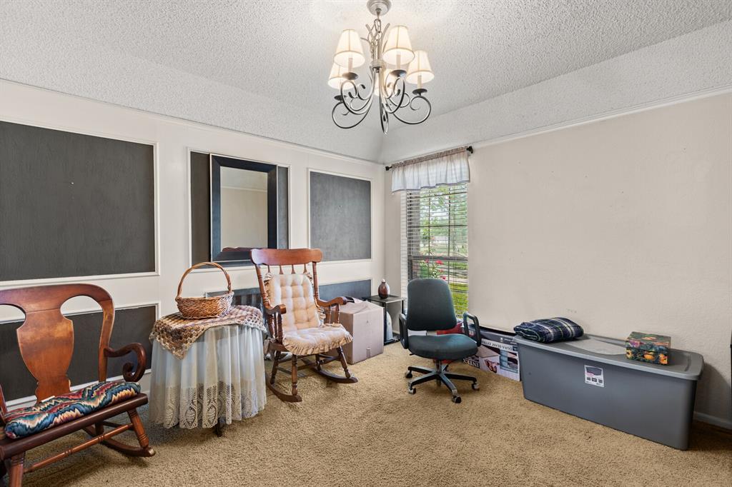 1502 Hinchliffe Road Mexia, TX 76667 - Photo 10 of 40 Living area featuring lofted ceiling, a textured ceiling, carpet flooring, and a notable chandelier