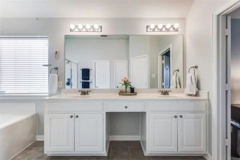 a spacious bathroom with double vanity and a mirror