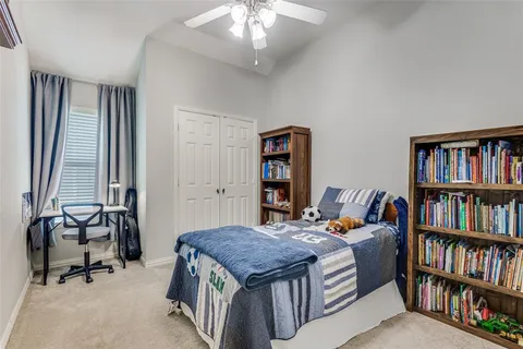 a bedroom with a bed a book shelf and a window