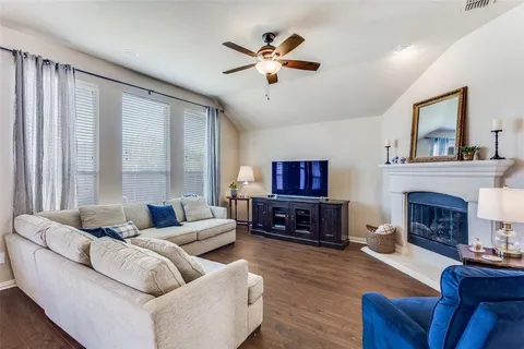 a living room with furniture a fireplace and a flat screen tv