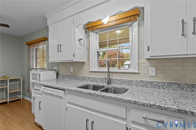 a kitchen with stainless steel appliances granite countertop a sink and a white cabinets