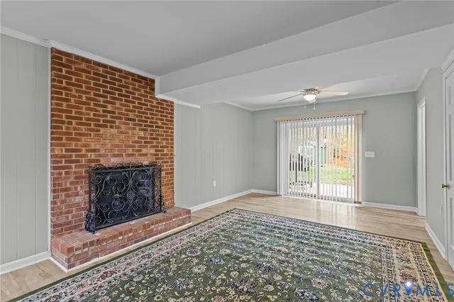 a view of an empty room with glass door and wooden floor
