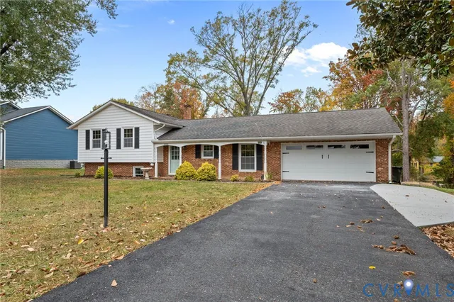 a view of a yard in front of a house with large tree