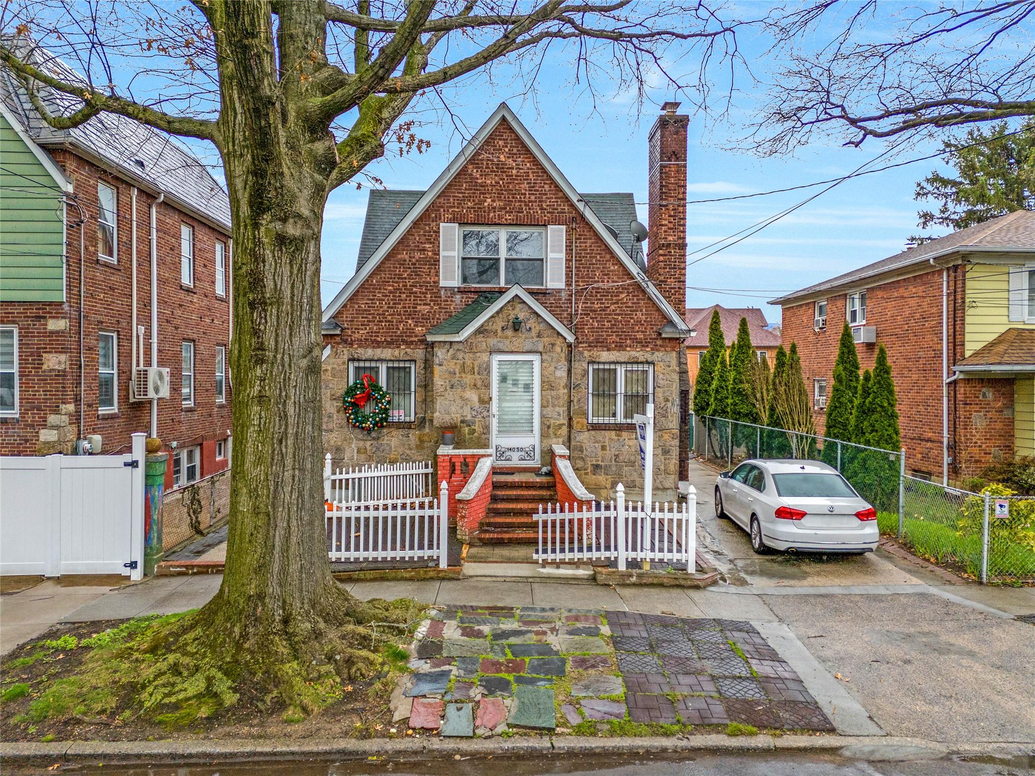140-50 Quince Avenue Queens, NY 11355 - Photo 3 of 13 a front view of a house with a garden