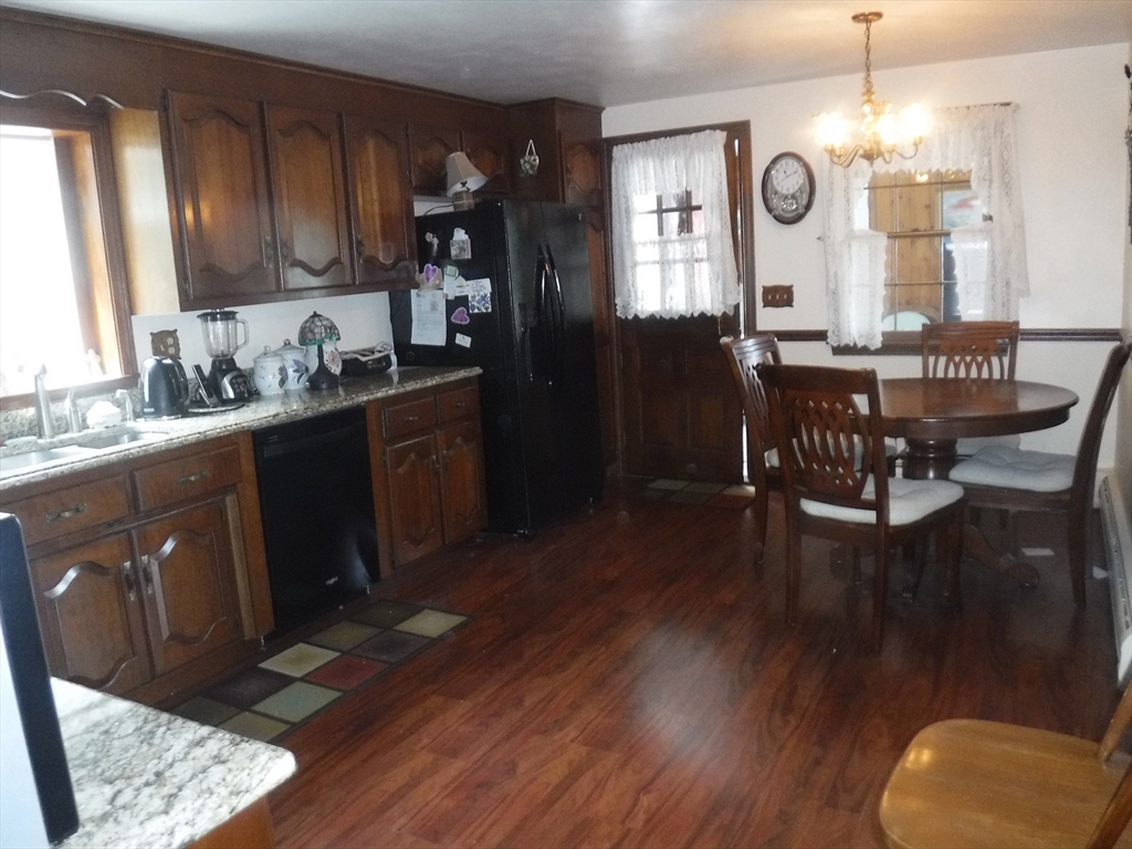 21 Old Orchard Road Hampden, MA 01036 - Photo 5 of 21 a kitchen with granite countertop a stove a sink dishwasher a dining table and chairs with wooden floor