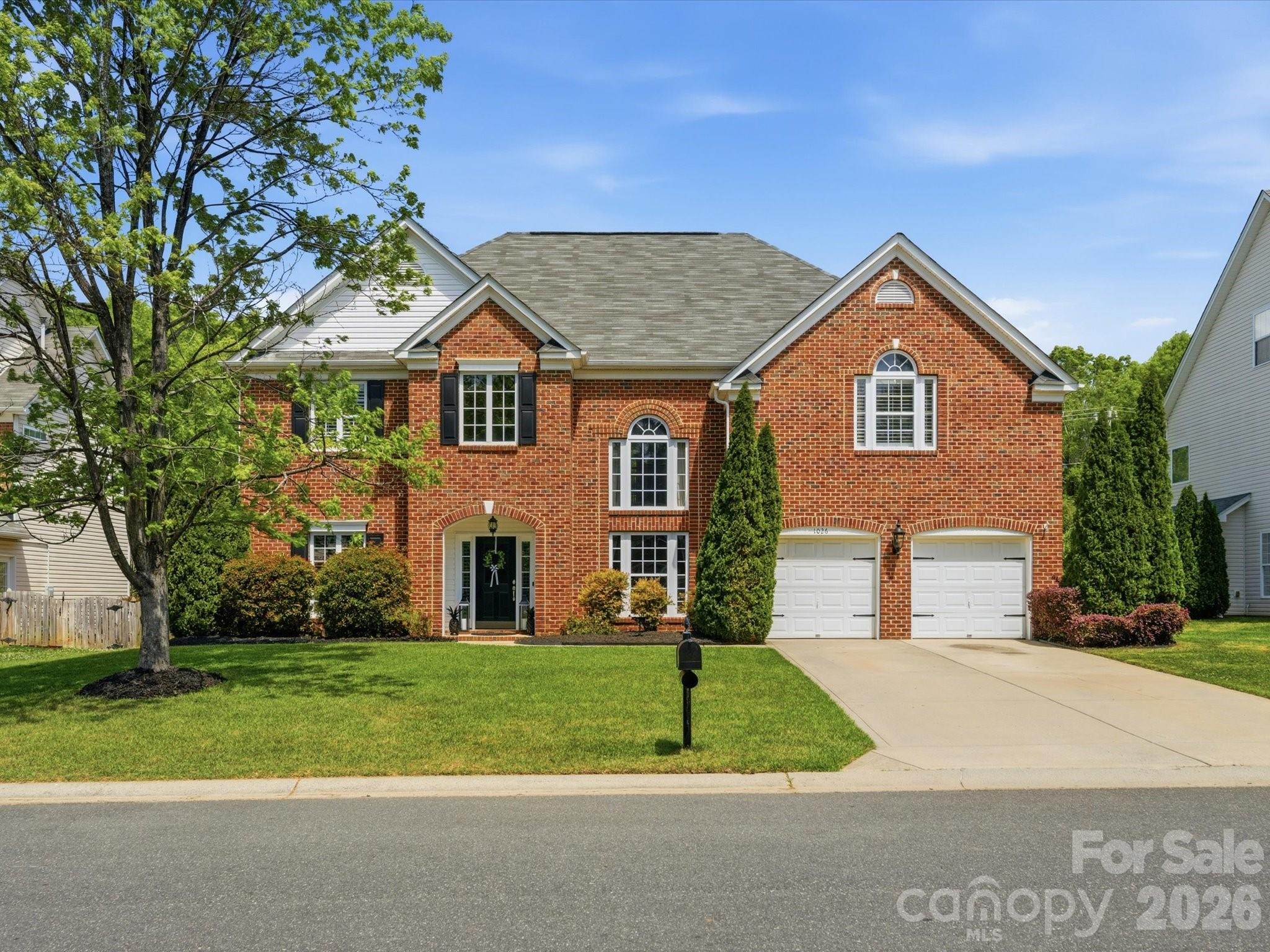 a front view of a house with a yard and trees