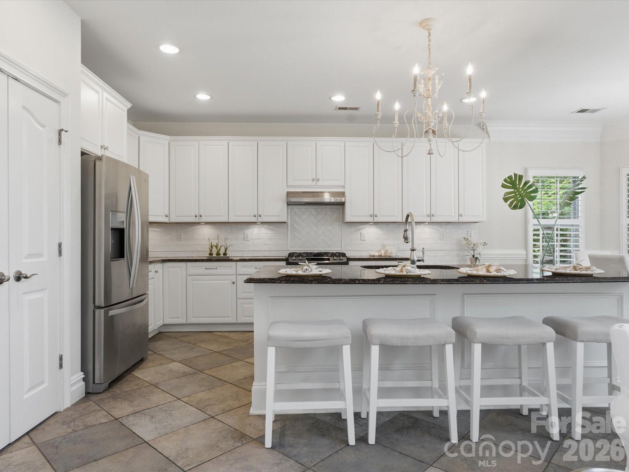 1026 Spanish Moss Road Indian Trail, NC 28079 - Photo 13 of 44 a kitchen with granite countertop white cabinets stainless steel appliances and a center island