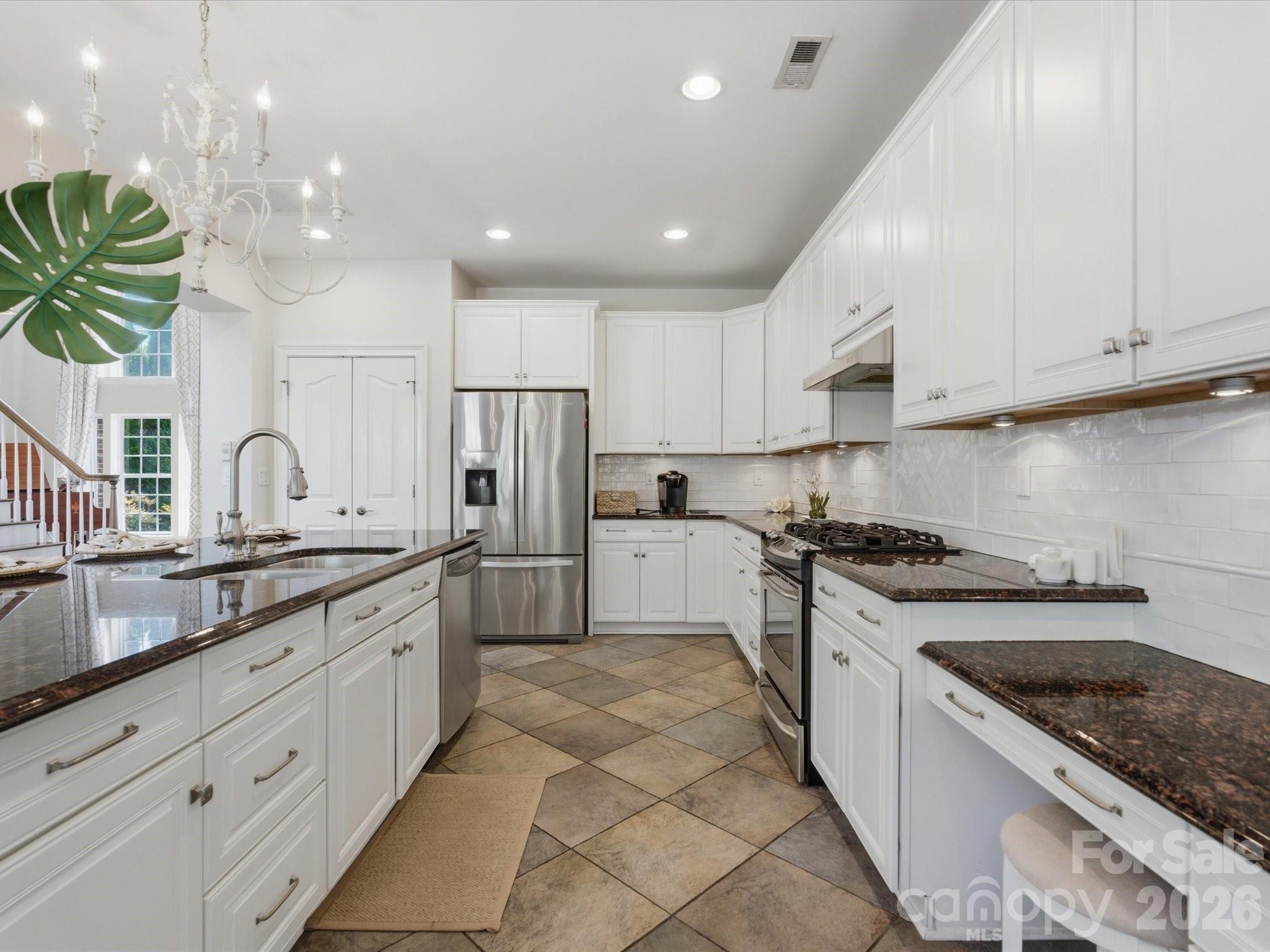 1026 Spanish Moss Road Indian Trail, NC 28079 - Photo 16 of 44 a large kitchen with stainless steel appliances granite countertop a sink a stove and a refrigerator
