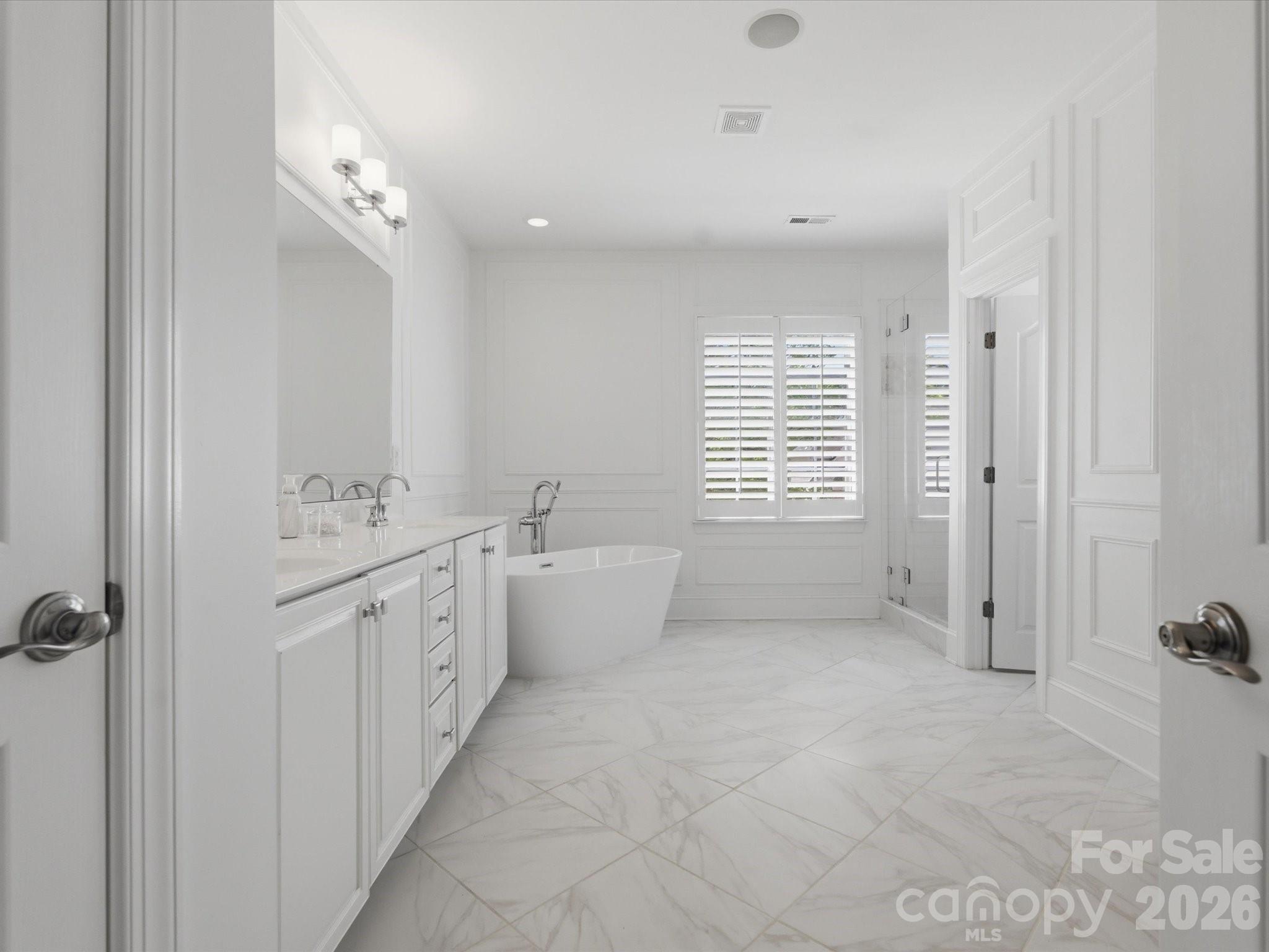 1026 Spanish Moss Road Indian Trail, NC 28079 - Photo 26 of 44 a spacious bathroom with a double vanity sink a mirror and a bathtub