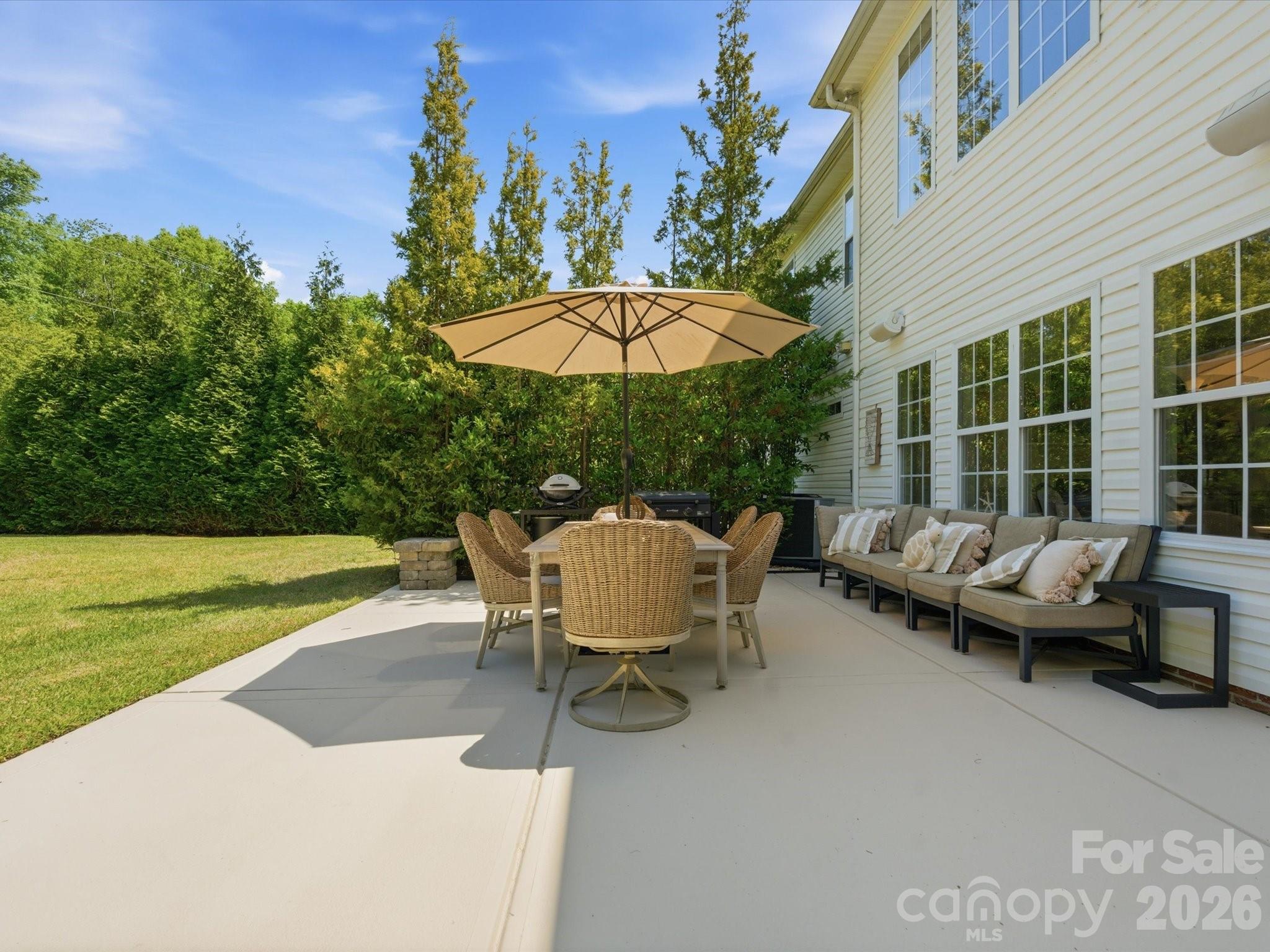 1026 Spanish Moss Road Indian Trail, NC 28079 - Photo 34 of 44 a view of a patio with lawn chairs under an umbrella