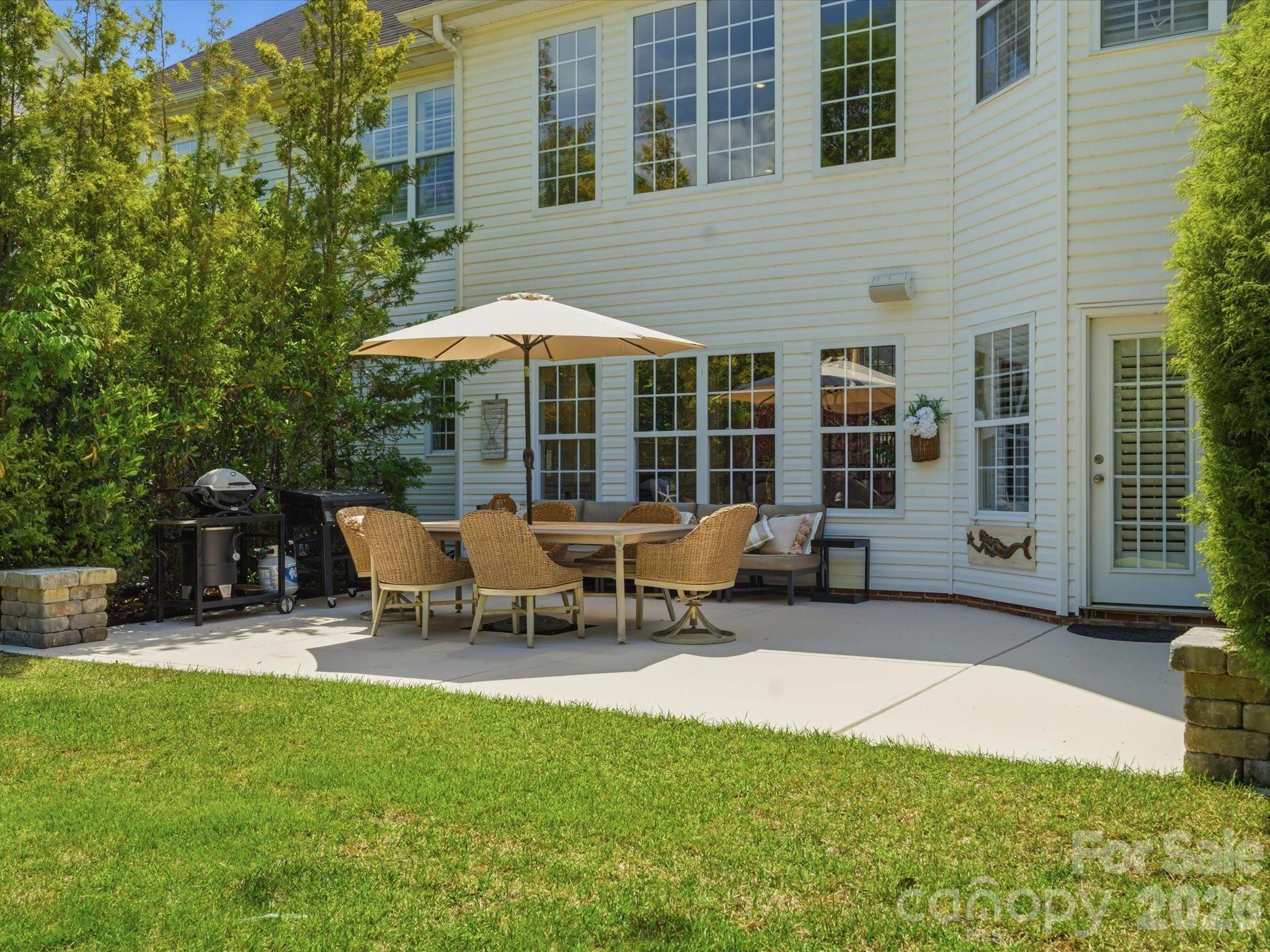1026 Spanish Moss Road Indian Trail, NC 28079 - Photo 35 of 44 a view of a patio with table and chairs under an umbrella