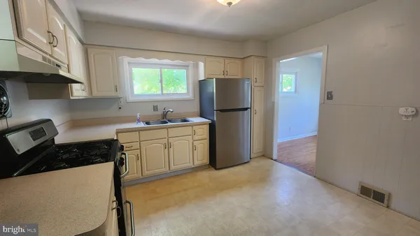 a kitchen with a refrigerator and a stove top oven