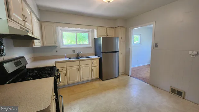 a kitchen with a refrigerator and a stove top oven