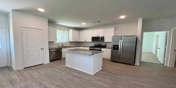 a kitchen with a refrigerator a sink dishwasher and a stove with wooden floor