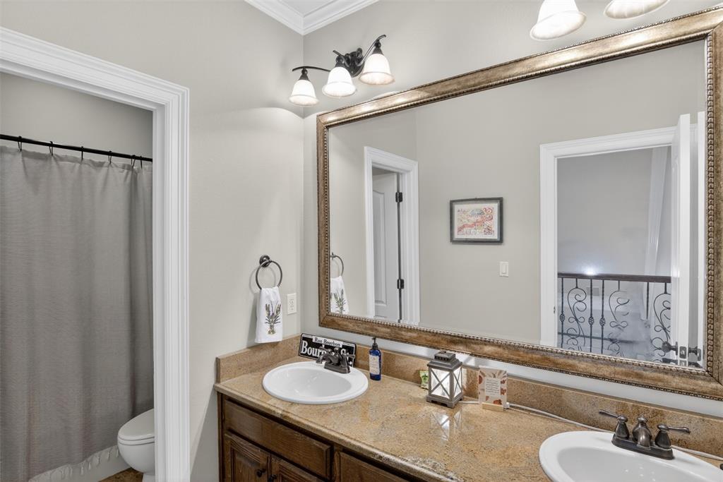 11868 Timber Ridge Drive Keithville, LA 71047 - Photo 27 of 37 Bathroom vanity featuring dual undermount sinks, a stone countertop, and a dark wood-finish cabinet