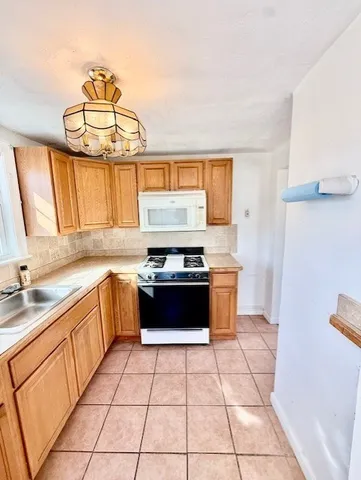 a kitchen with a stove top oven sink and cabinets