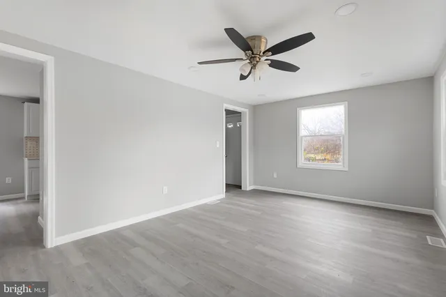 a view of a big room with wooden floor and windows
