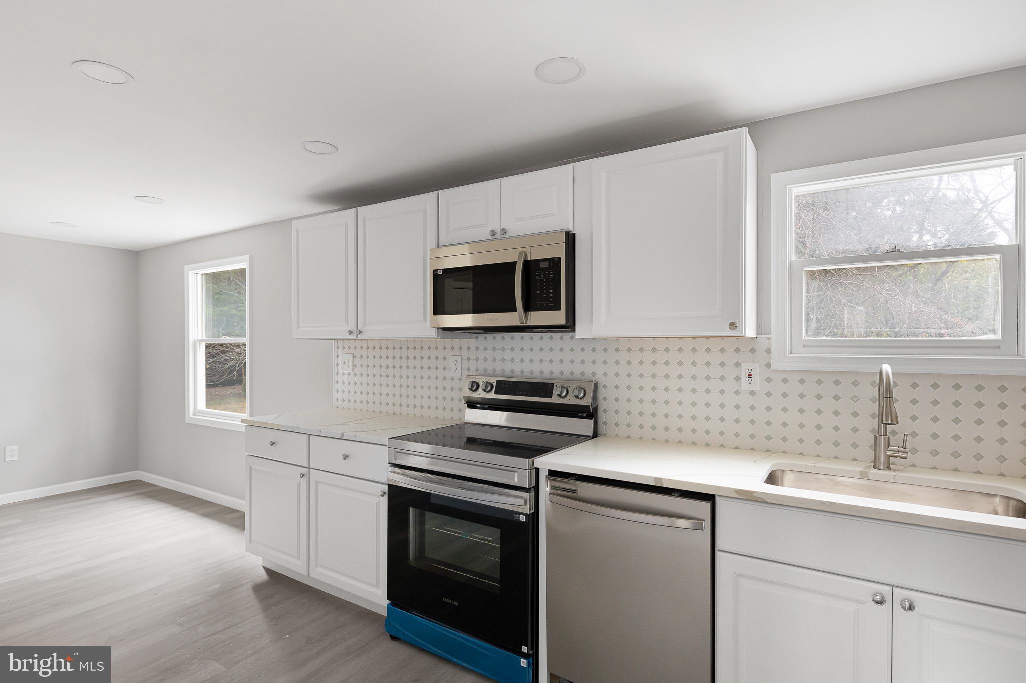 136 State Line Road Wilmington, DE 19803 - Photo 6 of 23 a kitchen with sink a microwave a stove and cabinets